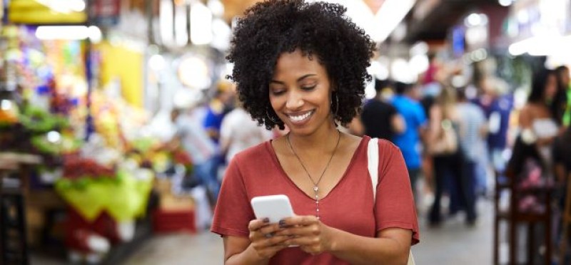 A smiling woman looking at her phone